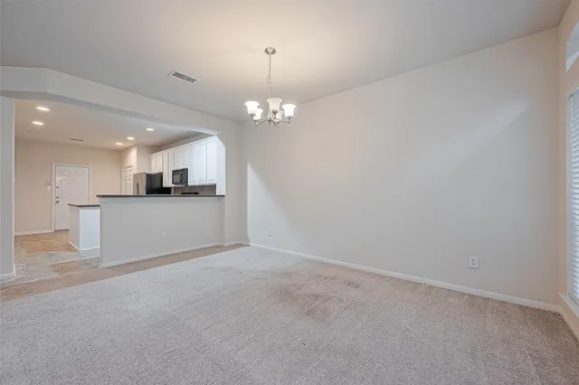 a view of a kitchen with a sink wooden cabinets and a refrigerator
