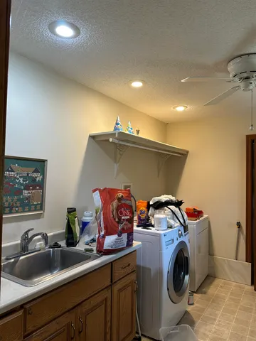 a utility room with sink dryer and washer