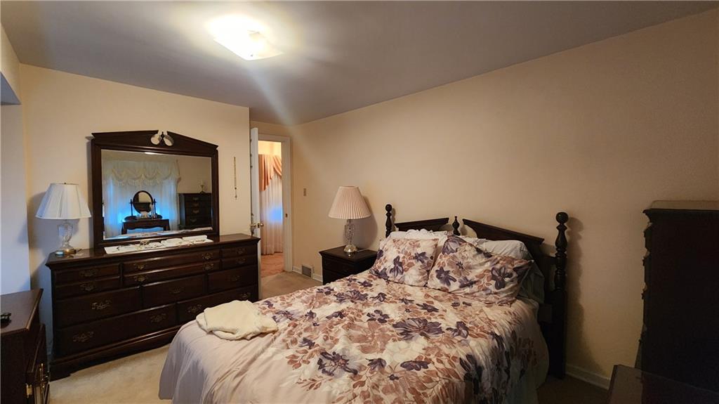 525 Burns Street Vandergrift, PA 15690 - Photo 14 of 25 a bedroom with a bed and a mirror on dresser