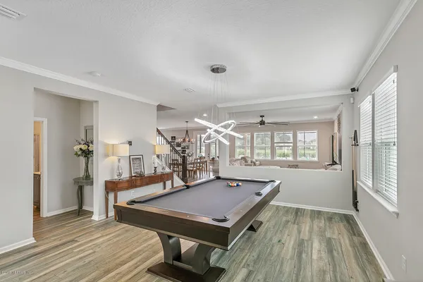 a room with pool table and windows