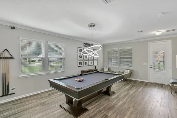 a room with pool table and windows