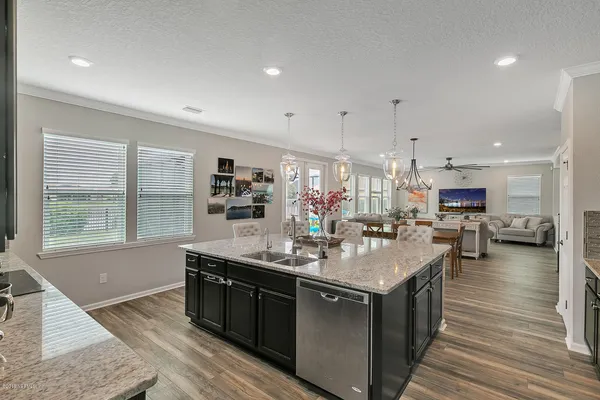 a kitchen with stainless steel appliances granite countertop a sink stove and wooden floor
