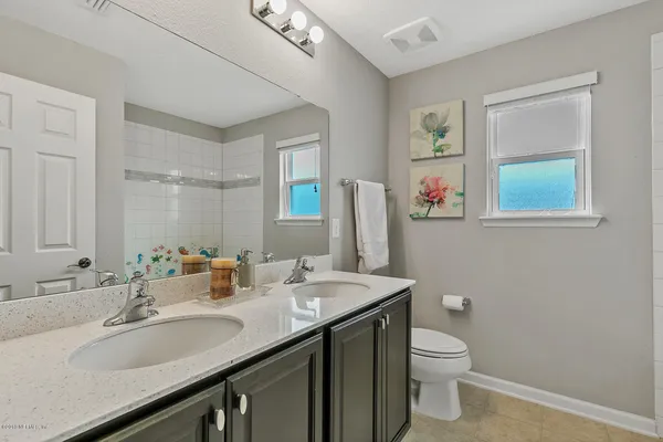a bathroom with a granite countertop sink toilet and mirror