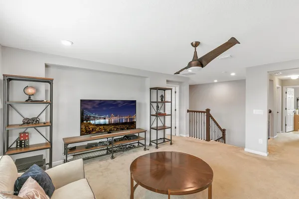 a living room with furniture pool table and a flat screen tv