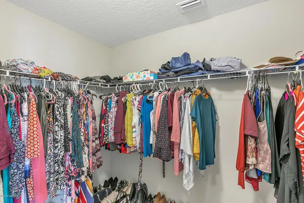 a view of walk in closet with clothes