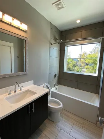 an empty room with kitchen view and wooden floor