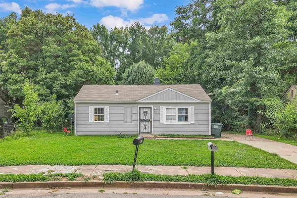a view of a house with a backyard and a tree