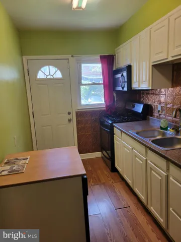 a kitchen with kitchen island granite countertop a sink stove and cabinets