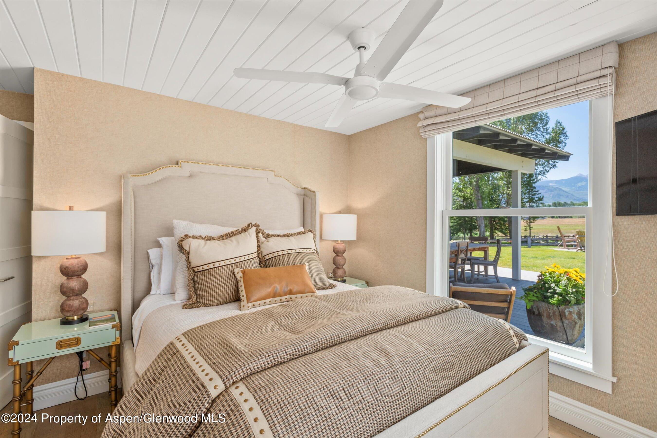 91 Alexander Avenue Snowmass, CO 81654 - Photo 20 of 32 a bedroom with a large bed and a large window with outer view