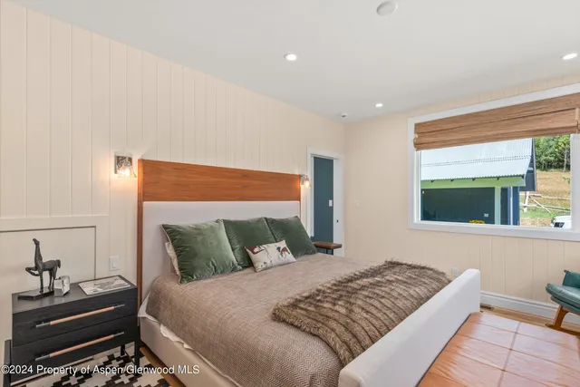 a bedroom with furniture and a flat screen tv