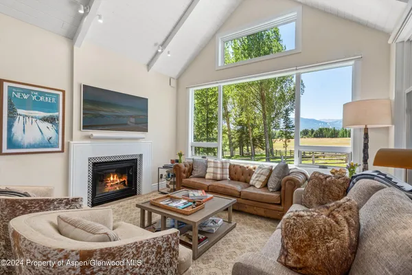 a living room with furniture a large window and a flat screen tv