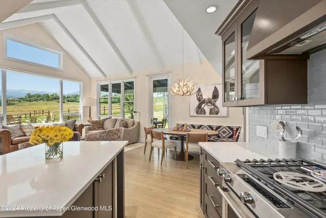 a kitchen with a sink a counter and chairs