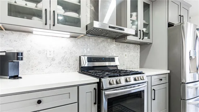 a kitchen with stainless steel appliances a stove and a microwave