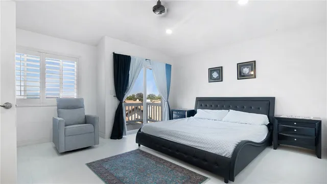 a bedroom with a bed a couch and a flat tv screen on a dresser