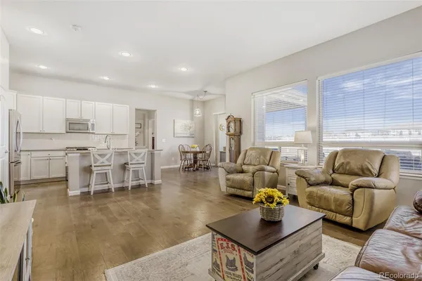 a living room with furniture and a view of kitchen
