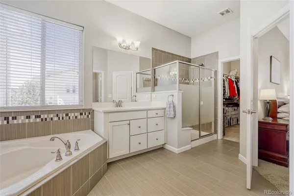a bathroom with a tub a sink and a shower