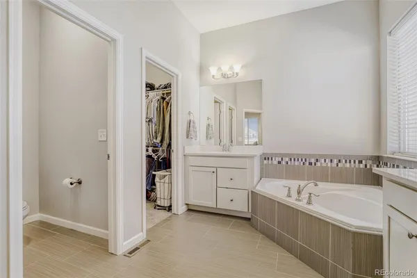 a bathroom with a tub sink shower and mirror