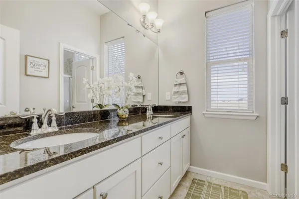 a bathroom with double vanity and a mirror