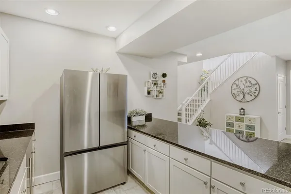 a kitchen with stainless steel appliances granite countertop a refrigerator and a sink