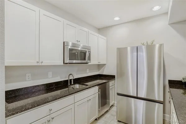 a kitchen with stainless steel appliances granite countertop a refrigerator sink and cabinets