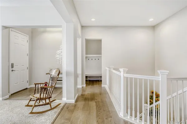 a view of a hallway with wooden floor and furniture