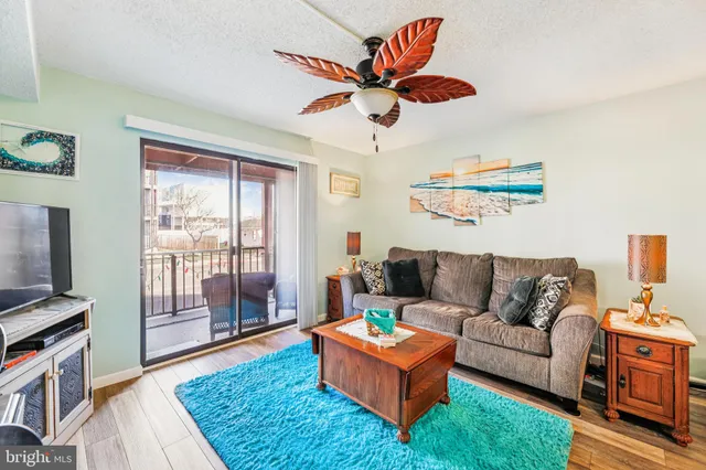 a living room with furniture a flat screen tv and a window