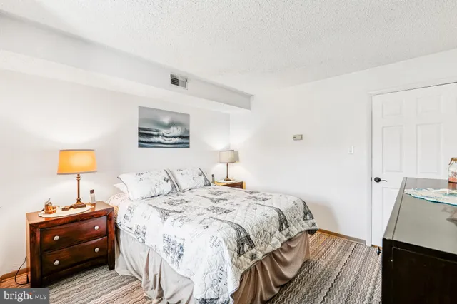 a bedroom with a bed and a lamp on dresser