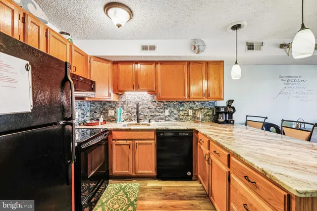 a kitchen with stainless steel appliances granite countertop a sink a stove and a refrigerator