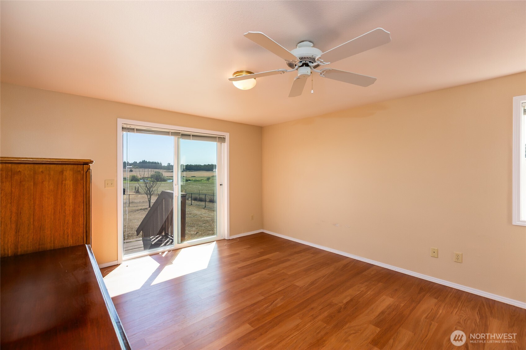 549 Davis Bay Road Lopez Island, WA 98261 - Photo 19 of 37 an empty room with wooden floor fan and windows