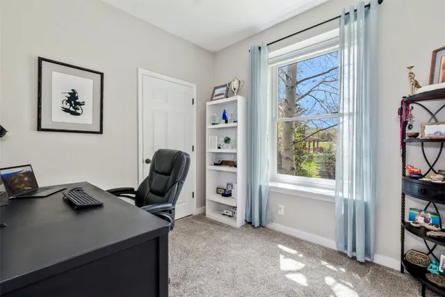 a view of a workspace with furniture and a window