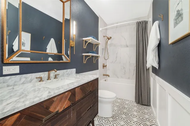 a bathroom with a granite countertop sink toilet and shower