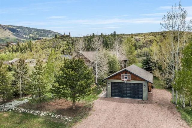 a view of a house with a yard and mountain view in back