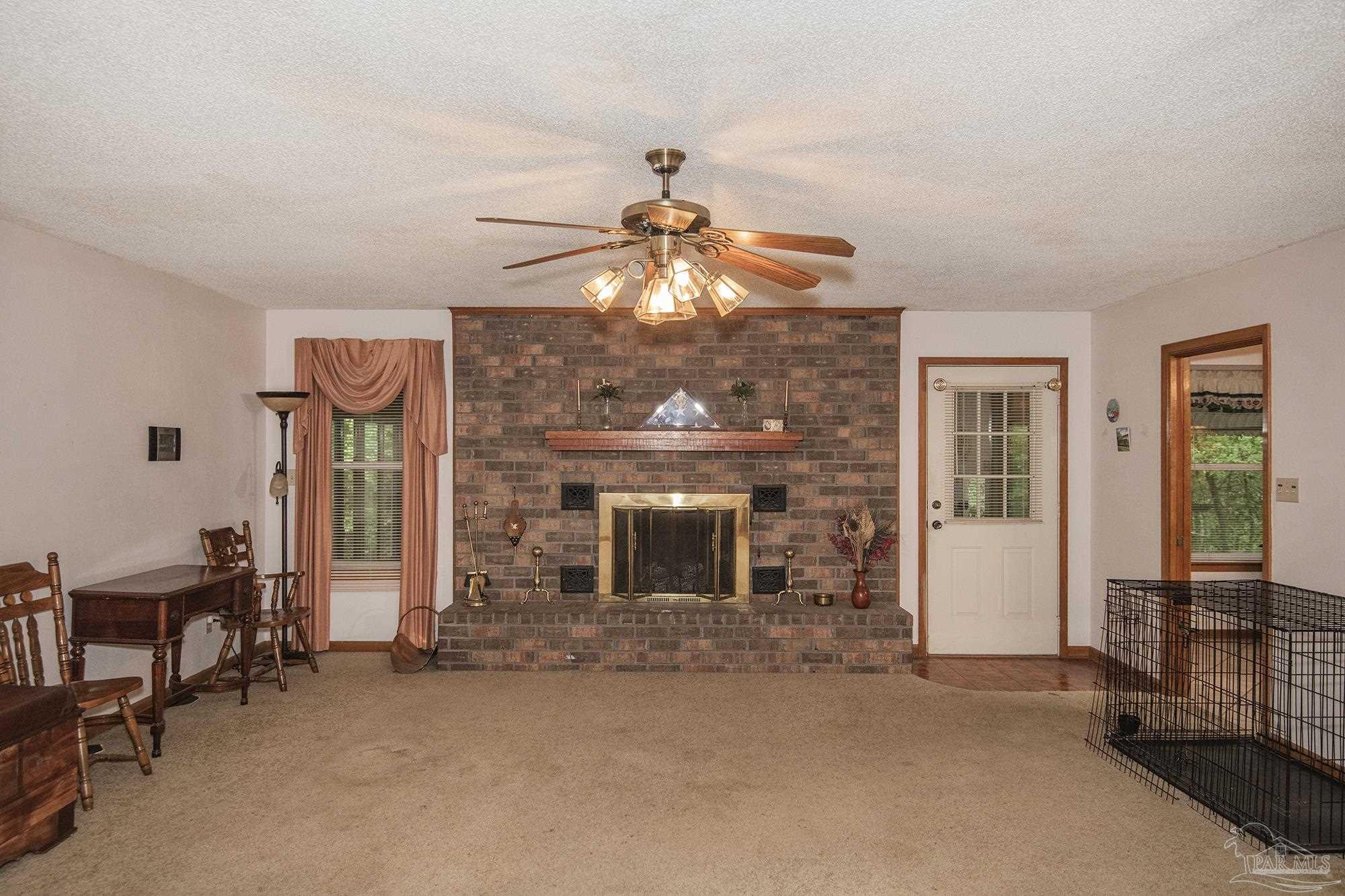1210 Goldenrod Road Cantonment, FL 32533 - Photo 12 of 50 a living room with fireplace furniture and a window