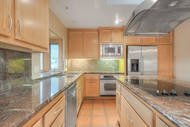 a kitchen with granite countertop a sink and a stove