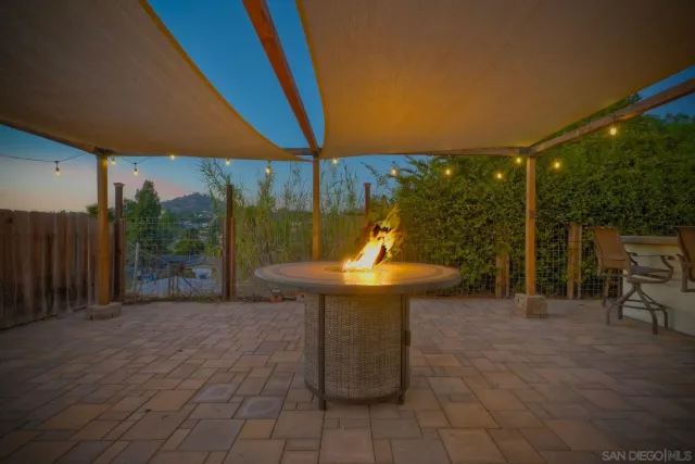 a view of a backyard with table and chairs potted plants with wooden fence