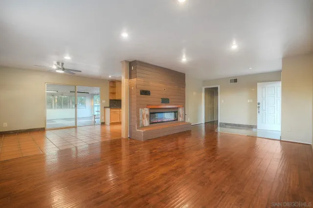 a view of empty room with wooden floor and fireplace