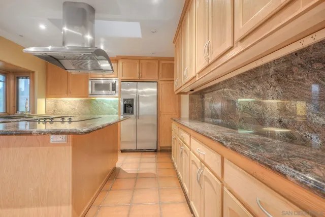 a kitchen with stainless steel appliances granite countertop a sink and a refrigerator