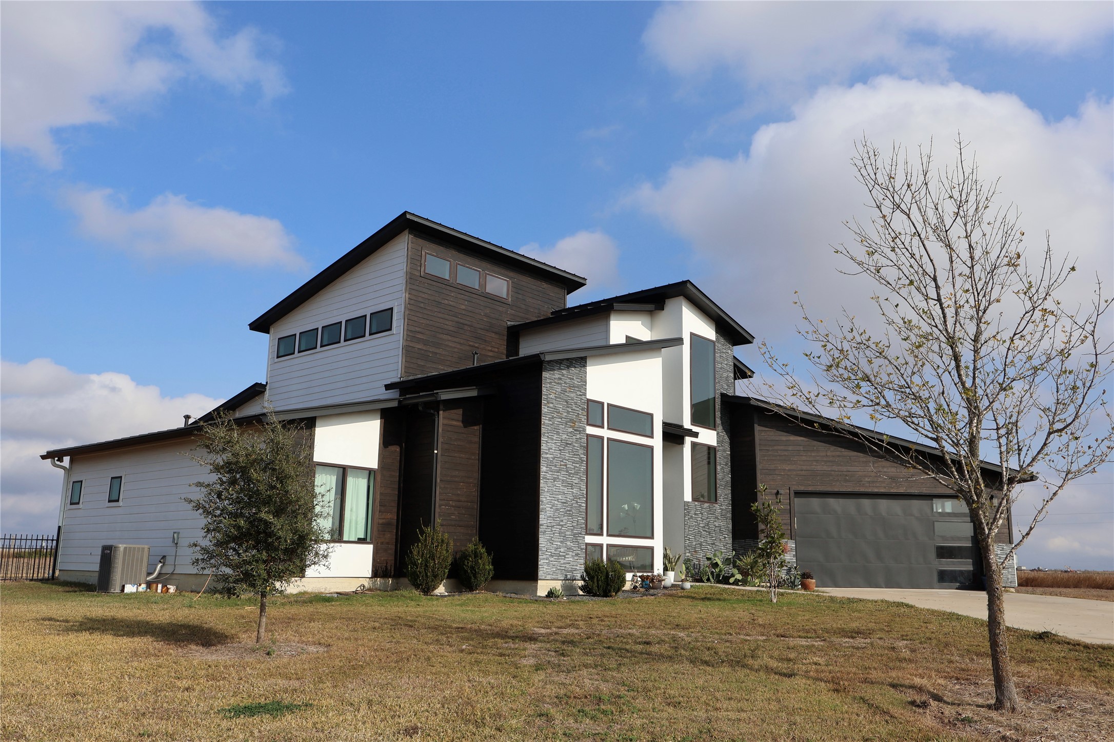 17216 Lund - Carlson Road Elgin, TX 78621 - Photo 12 of 17 View of front of property with a front lawn, stone siding, concrete driveway, and a garage