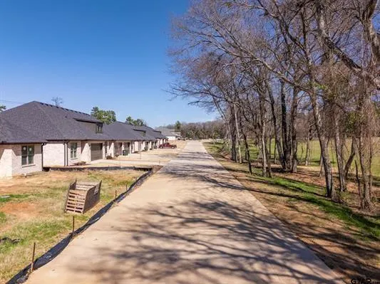 a view of house with yard and trees in the background