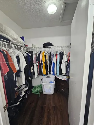 a view of walk in closet with clothes