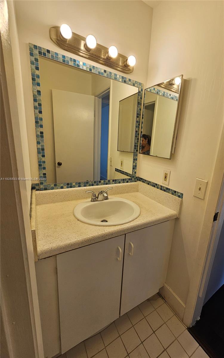 1002 Adams Avenue, Unit 1002E Homestead, FL 33034 - Photo 6 of 13 a bathroom with a sink and a mirror