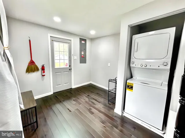 a view of storage and utility room with wooden floor washer and dryer