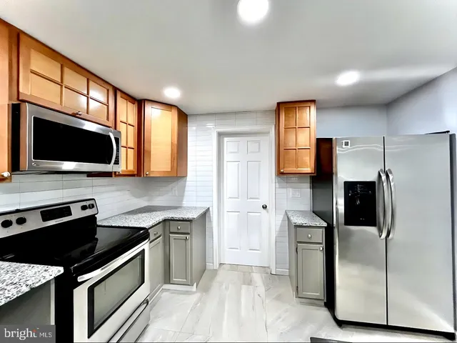 a kitchen with stainless steel appliances granite countertop a stove a sink and a refrigerator