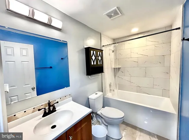 a bathroom with a sink a toilet a mirror and shower