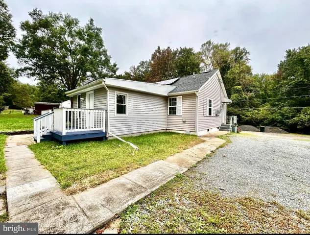 a view of a house with a yard and sitting area
