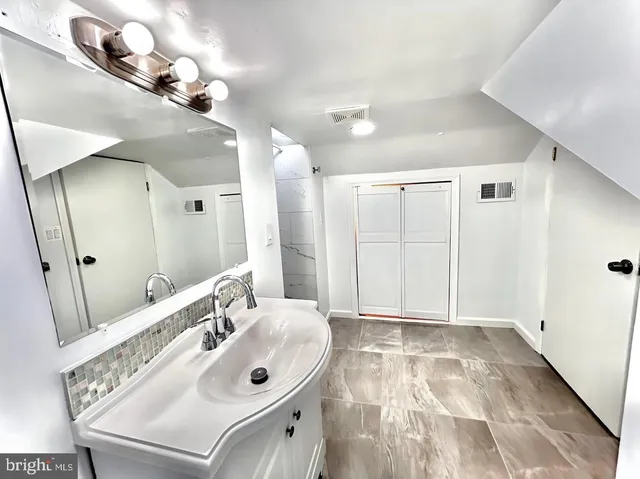a bathroom with a sink mirror and vanity