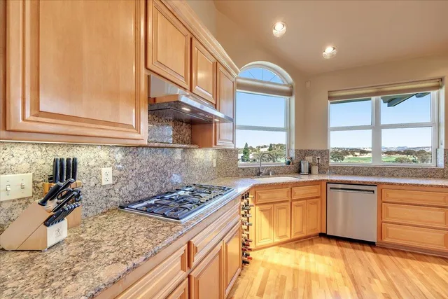 a kitchen with stainless steel appliances granite countertop a refrigerator and a stove