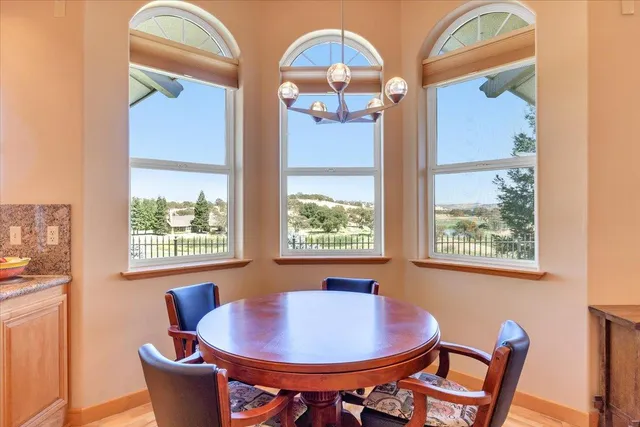 a view of a patio with couches and table and chairs and wooden fence