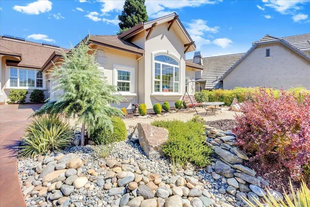 a dining room with wooden floor a chandelier and a rug