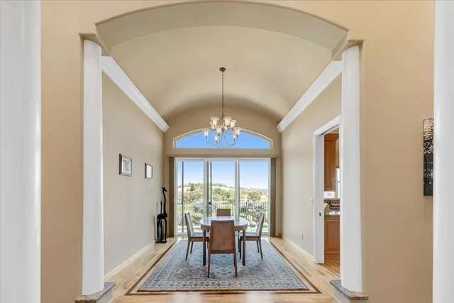 a dining room with furniture a chandelier and wooden floor